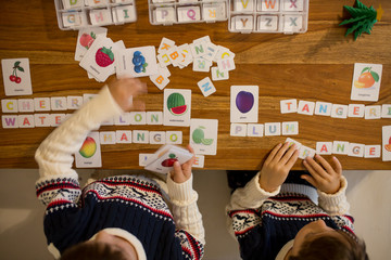 Children, writing words with cut letters and learning english words