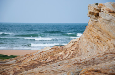 Fototapeta na wymiar macro de roca con fondo de olas del mar, espacio para texto