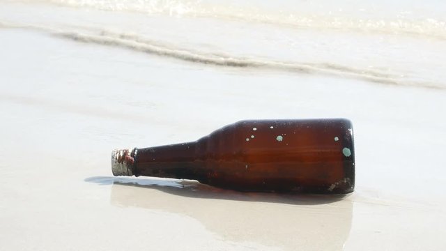 Glass bottles at the beach hit the sea, Waste is thrown into the sea