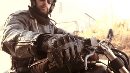 Naklejka premium Motocyklista w skórzanych rękawiczkach na rączce gotowy do pracy