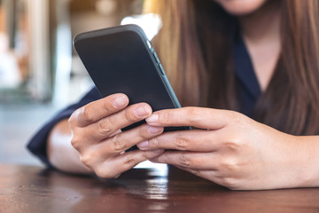 Closeup image of a woman holding , using and touching a smart phone