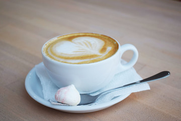 Cup of aromatic coffee on wooden background.