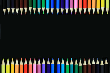 Color pencils isolated sort in black background with copy space.