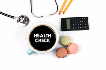 health check concept. coffee mug and macarons biscuits on a white table