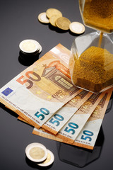 sanduhr mit geldscheinen