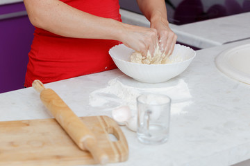 Making dough by female hands in bowl at home kitchen