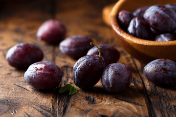 Fresh ripe plums on wooden desk