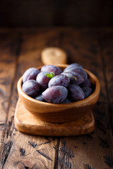 Fresh ripe plums on wooden desk