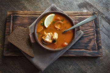 Marmitako soup in a ceramic bowl on a wooden board