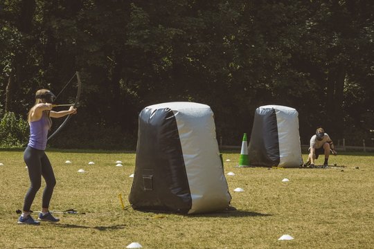 Man and woman practicing archery at boot camp