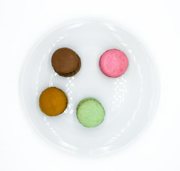 Obraz na płótnie Canvas macarons on plate, sweet colorful macarons on white background