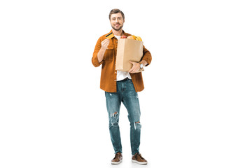 happy man with shopping bag full of products showing credit card isolated on white