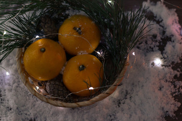 Fototapeta na wymiar Sweet christmas mandarin fruit in a basket with christmas fir tree branch
