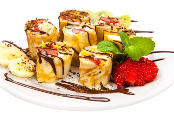 Tasty roll of pancakes with fruits and berries isolated on White Background. Fresh Homemade Crepes