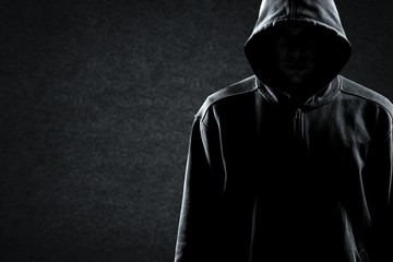 Thief in black clothes on grey background