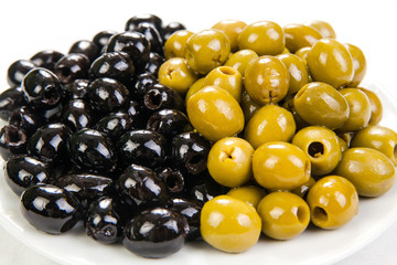 fresh black and green olives on the plate isolated on white background