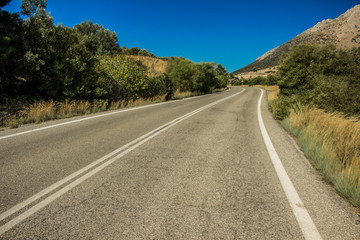 asphalt road near lonely mountain horizon landscape in warm dry summer weather