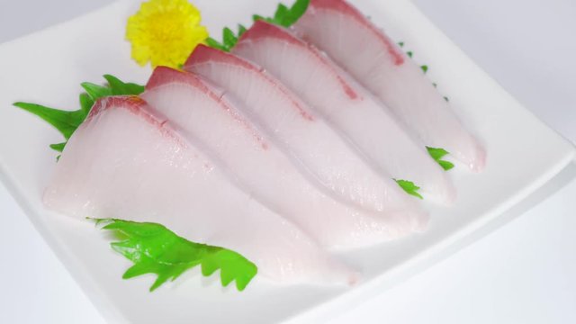 Japanese slices of yellowtail sashimi on white plate