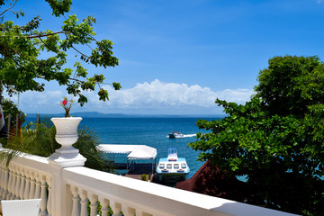 Fototapeta na wymiar View from terrace over the ocean with some boats, carribean sea, beautiful view through plants