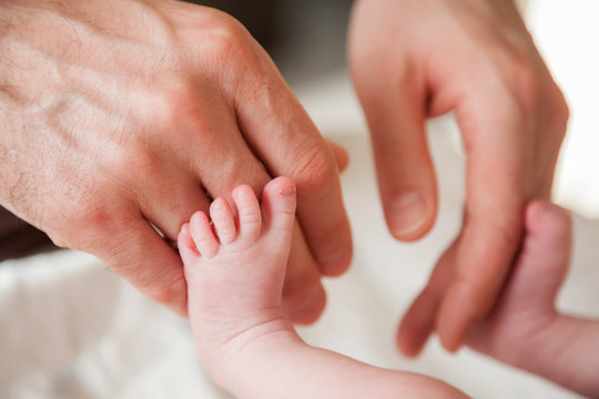 father's hands and baby's feet