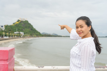 asian woman is  pointing ot  Thammikaram Temple at Khao Chong Krachok