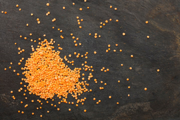 Dried lentils scattered on slate natural background