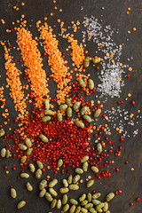 Dried lentils and soya beans  with red peppercorns and rock salt scattered on slate natural background - portrait
