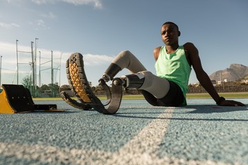 Disabled young athlete relaxing on running track
