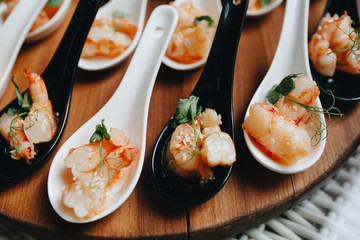 Seafood. Grilled prawns on small plates with spices and fresh herbs on a wooden rustic cutting table on a wooden background. Shrimp shrimp kebab. Barbecue shrimp.