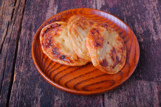 Akok Kedut on wooden plate over the wooden table. Akok Kedut is a traditional dish in Malaysia especially East Coast.