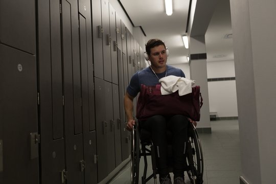 Disabled man listening to music on headphones in locker room