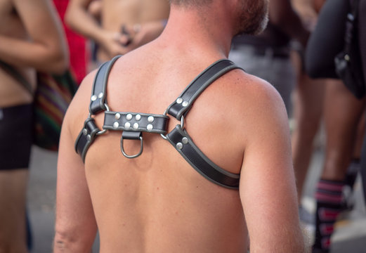 Bearded man with no shirt wearing black BDSM harness