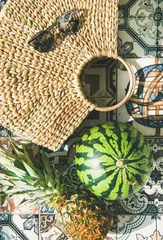Zelfklevend Fotobehang Summer lifestyle background. Flat-lay of summer fruit pineapple and watermelon, straw bag and sunglasses over colorful moroccan tile floor, top view © sonyakamoz