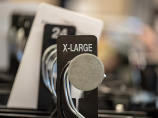 X-large end cap sign on steel clothes hanging rack with hangers in department store