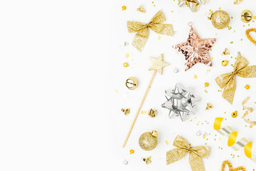 Christmas decorations, bows, stars,  bells in gold colors on white background with empty copy space for text. Holiday and celebration. Flat lay, top view