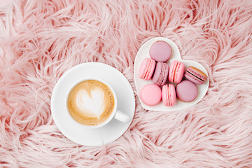 Cup of coffee with macaroons on the fluffy fur plaid.  Flat lay, top view