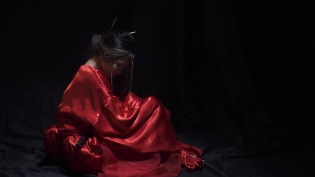 Pretty geisha looking over her shoulder into the camera, slow motion
