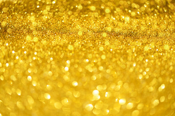 Holiday abstract texture. Christmas card with copy space. Gold bokeh background, defocused lights.