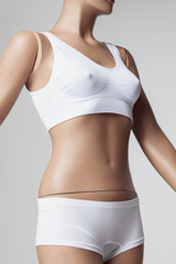 Fototapeta na wymiar The female mannequin in white underwear over gray studio background. The woman body, fit figure, fitness, diet, sports, plastic surgery and healthy lifestyle concept.