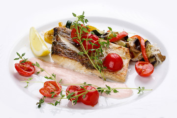 Pike perch with vegetables on a white dish.