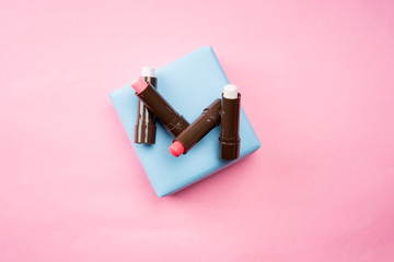 Cosmetic products arranged creatively on pastel colored background, flat lay view.