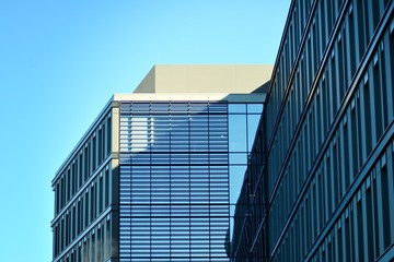 Modern office building facade abstract fragment, shiny windows in steel structure