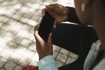 Couple using mobile phone in city street