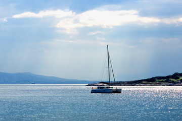 Sailing boat on the sea at sunset. Summer evening on an island in Greece.