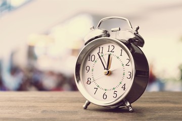 Gray retro alarm clock on wooden table background