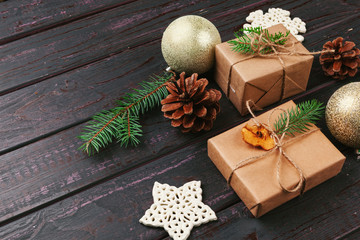 Christmas composition. Christmas gift, knitted blanket, pine cones, fir branches on wooden background.