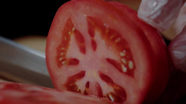 Chef making burger. Closeup mans hands cutting tomato for hamburger.