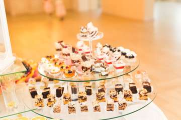 Delicious sweets on wedding candy buffet with desserts, cupcakes