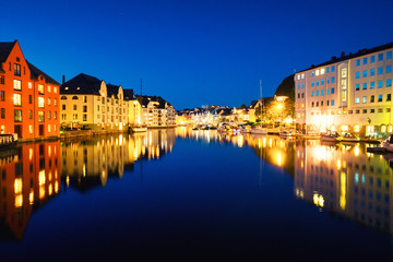 Fototapeta na wymiar View of center of Alesund, Norway at night with reflection in the river