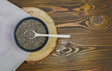 Healthy Chia seeds with wooden spoon on the table close-up. On wooden background